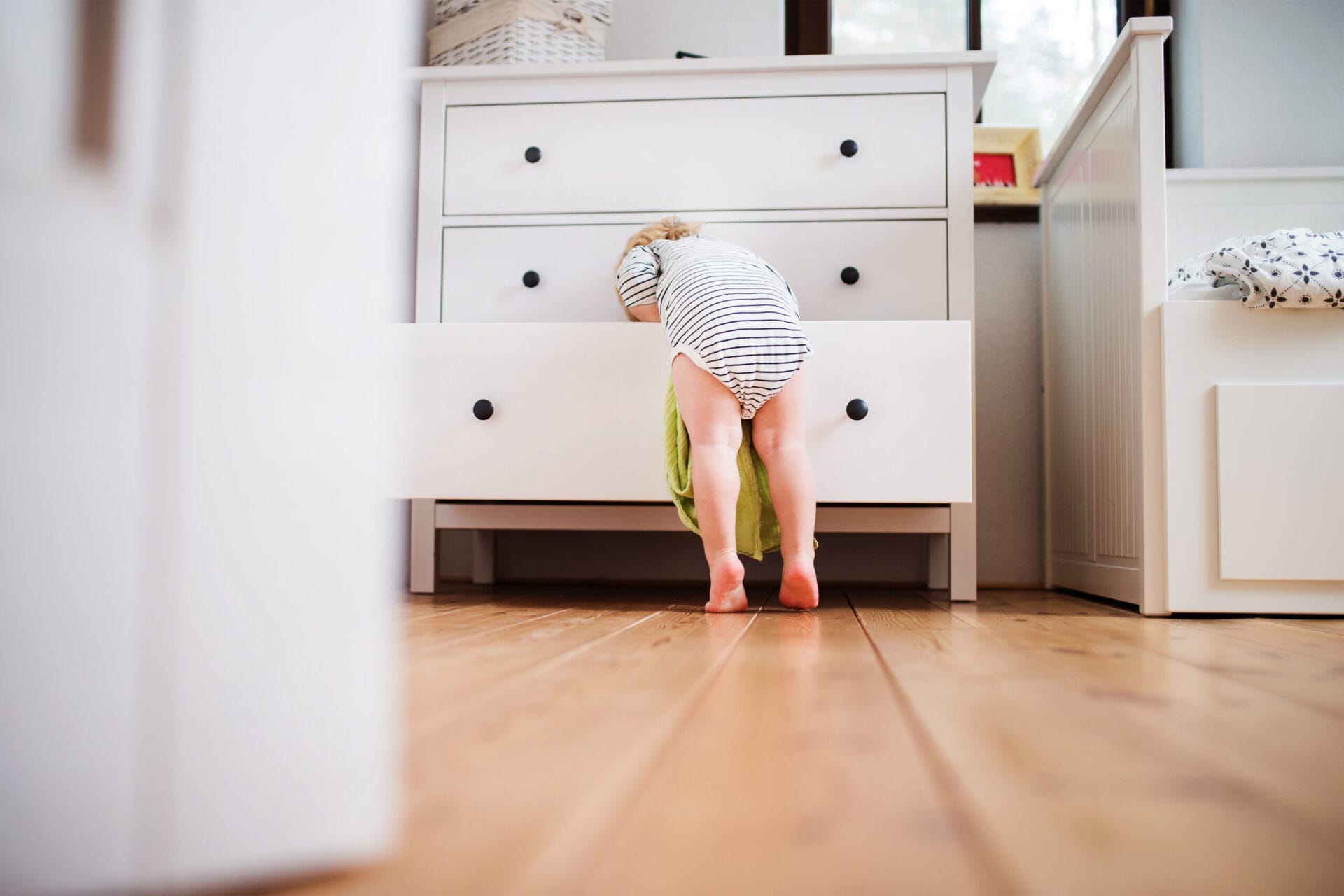 A baby climbing on a piece of furniture