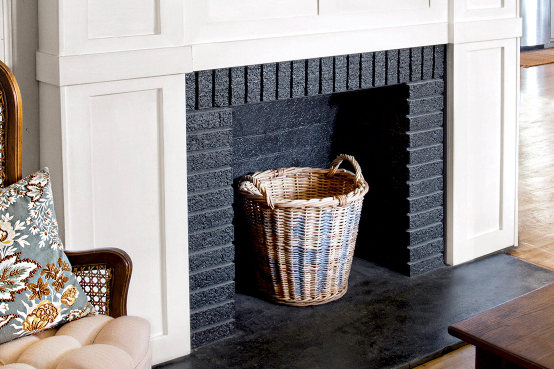 Finished Product, White wood trim brightens the fireplace, which is accented by a rustic mantelshelf; a black-painted firebox adds depth.