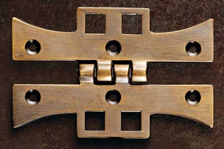 A set of cabinet hinges sitting on a table.