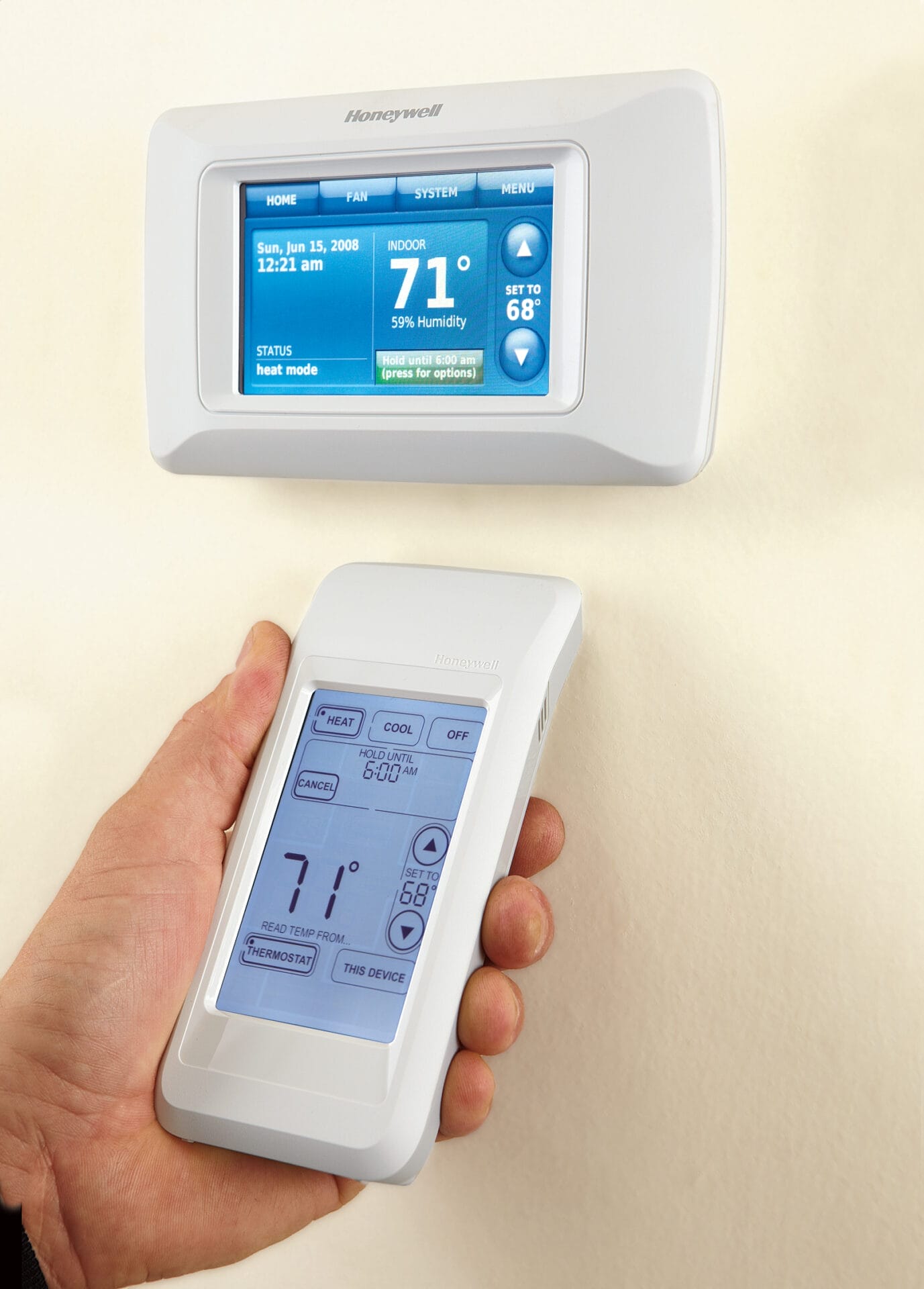 Photo of a person adjusting their programmable thermostat with a remote.