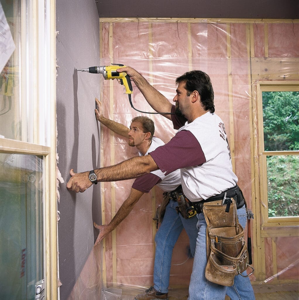 Contractors hanging drywall