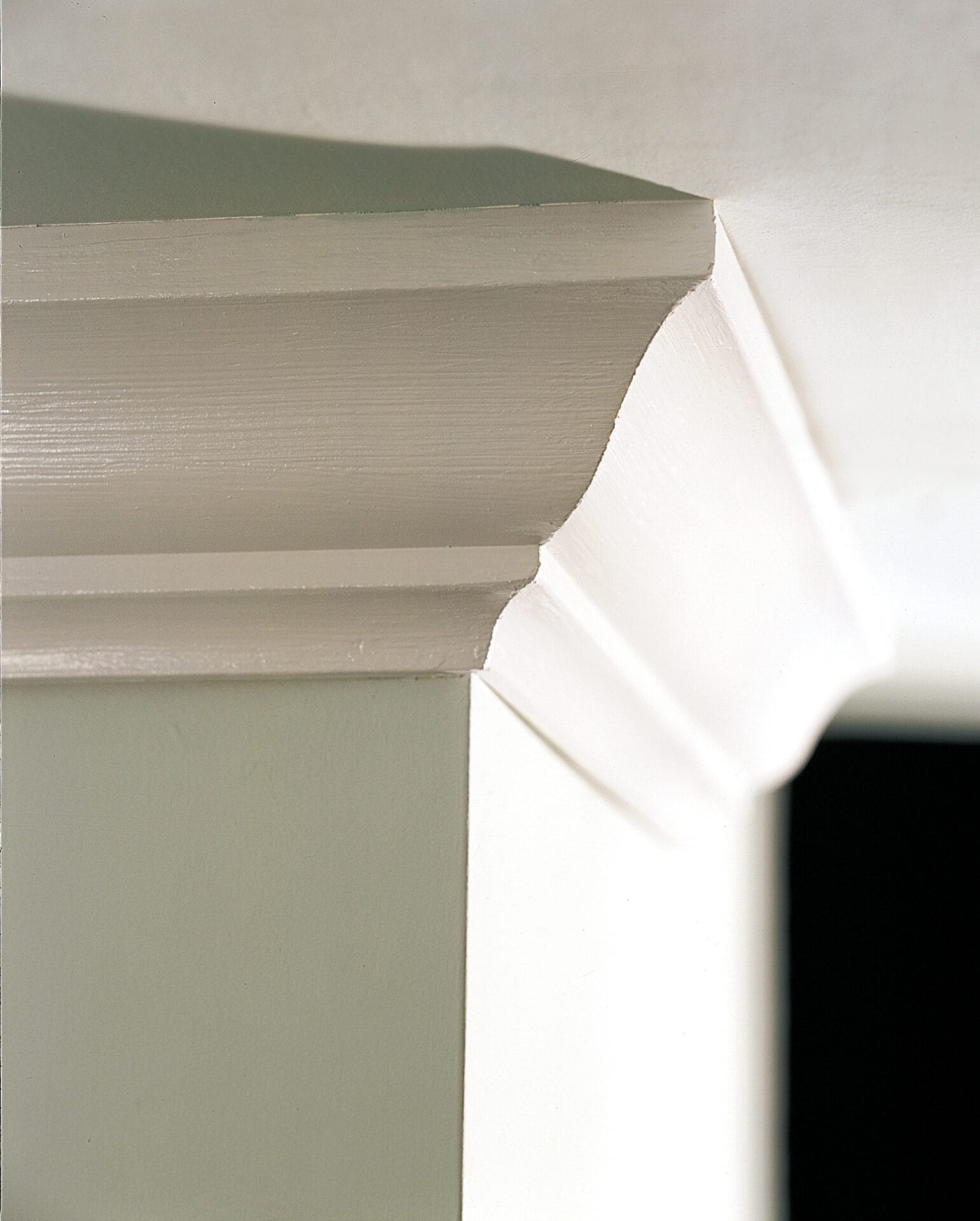 A zoomed in picture of crown molding affixed to the wall of a home.