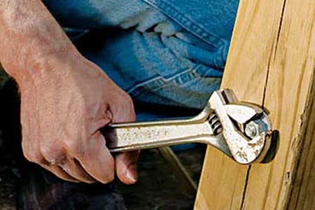 An adjustable wrench being used to screw a bolt