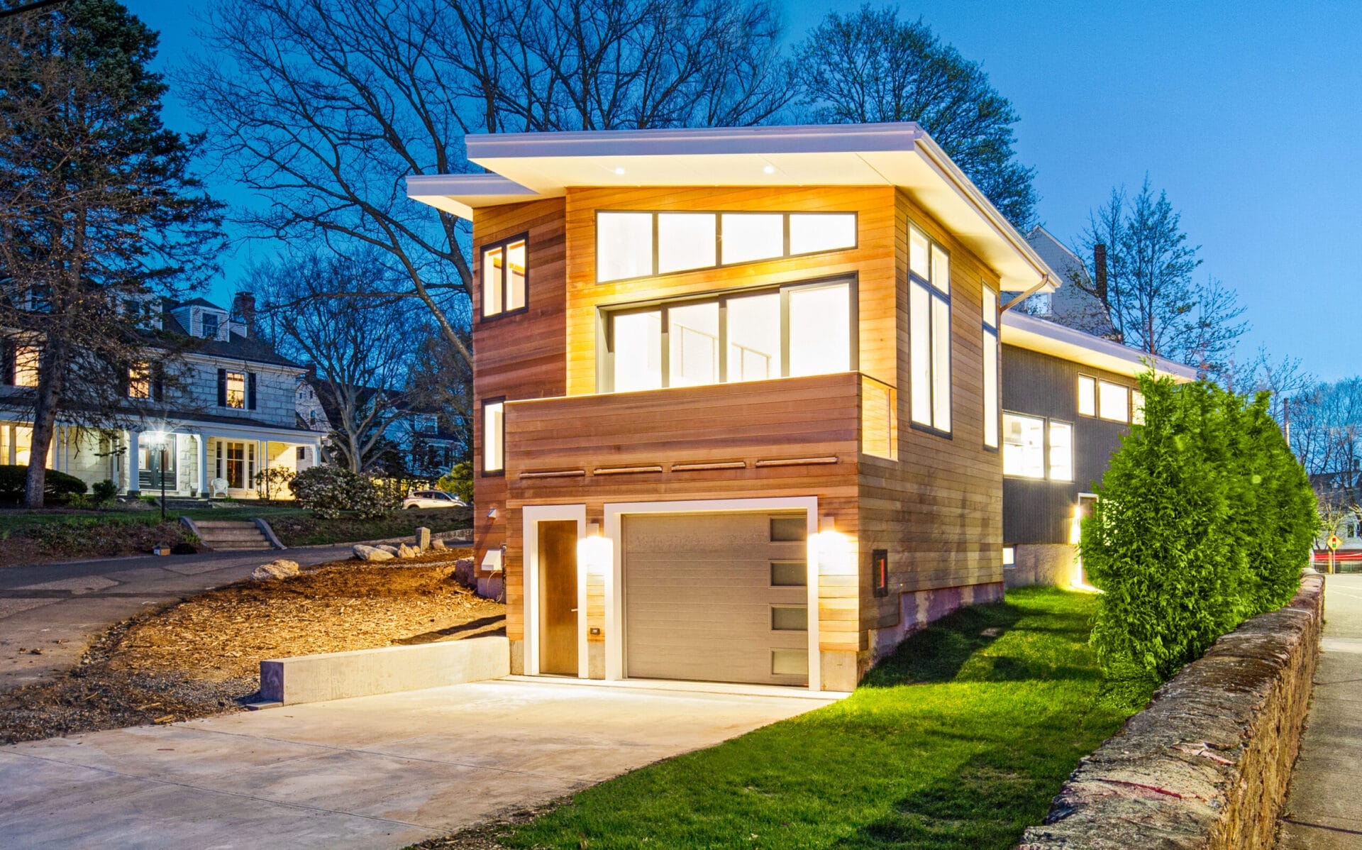 Illuminated house at night showcasing walls of glass and modern design.