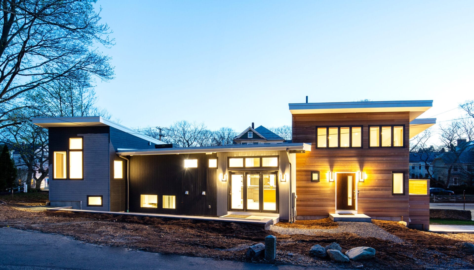 Renovated mid-century modern house exterior with angular cedar-clad additions.