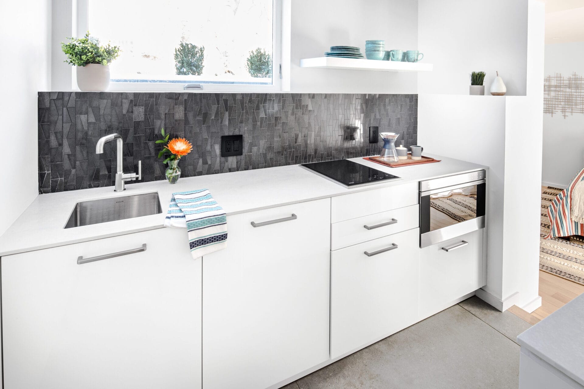 Guest kitchenette with compact appliances and modern cabinetry design.