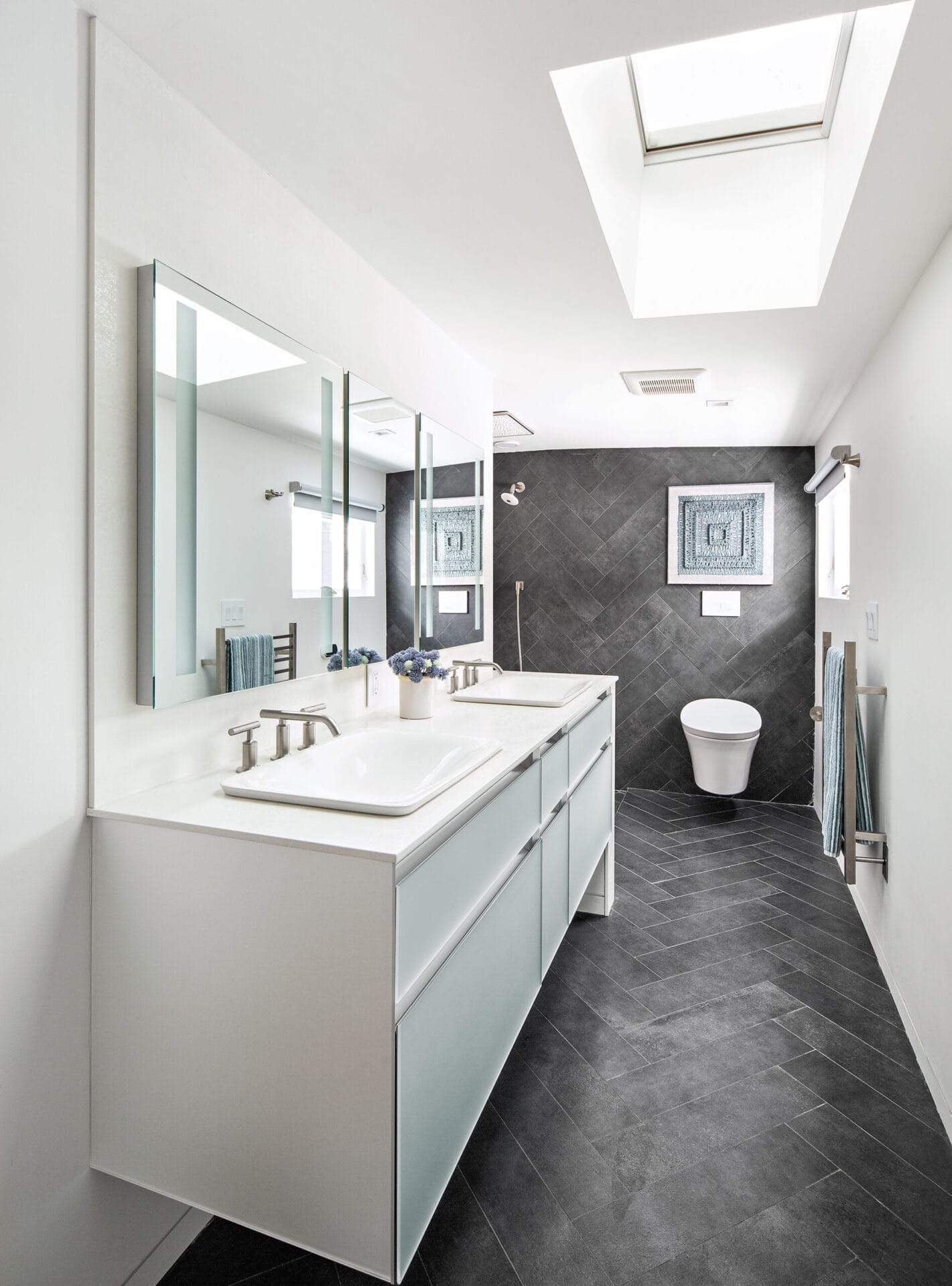 Master bathroom with dark tile planks and white double vanity setup.