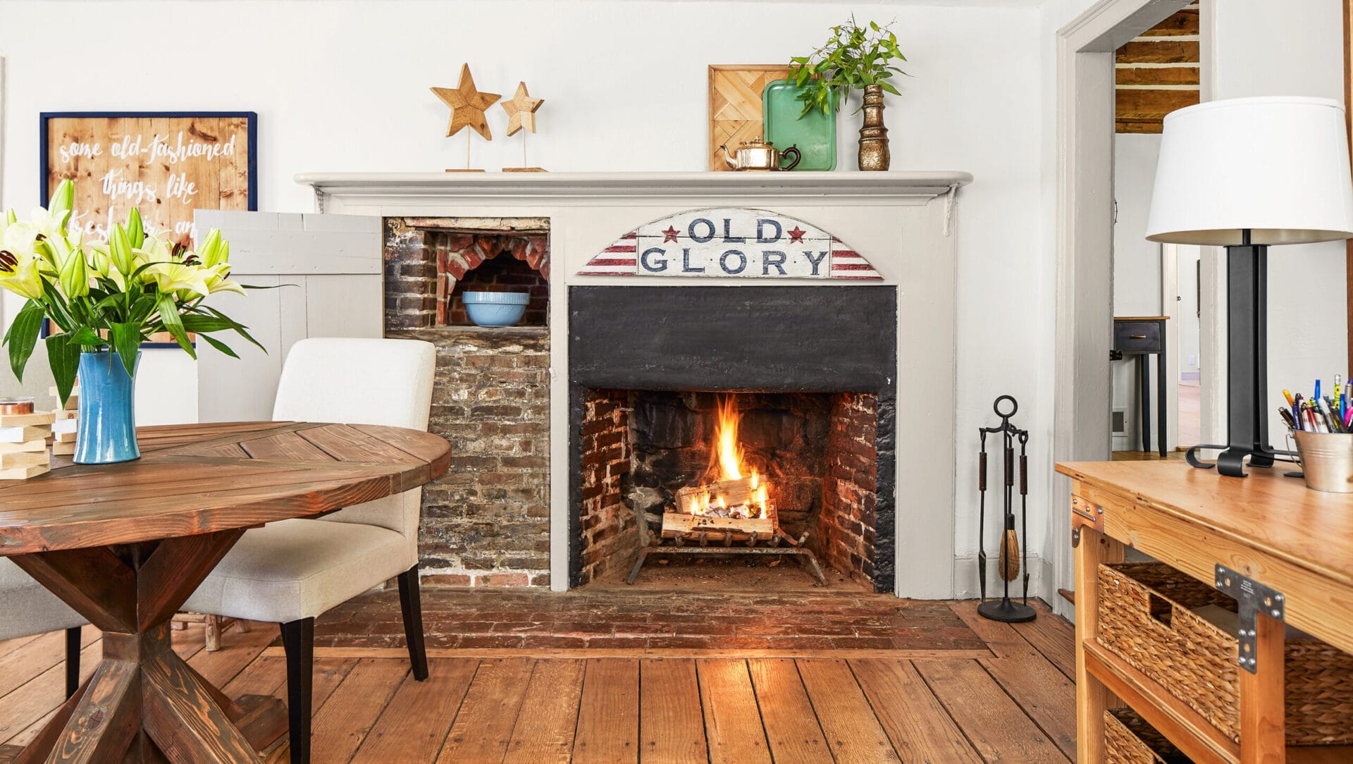 A living room fireplace with a sign that says "Old Glory" on the mantel.