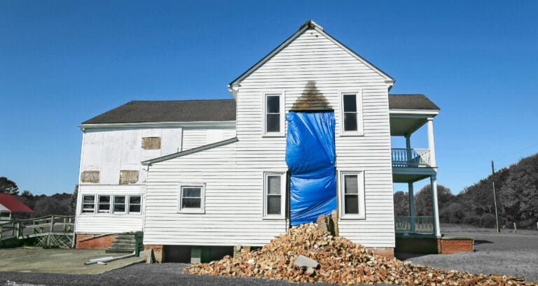 A rear view of the house with hurricane damage.