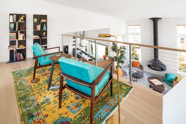 Loft space with steel cable railings overlooking open living area below.