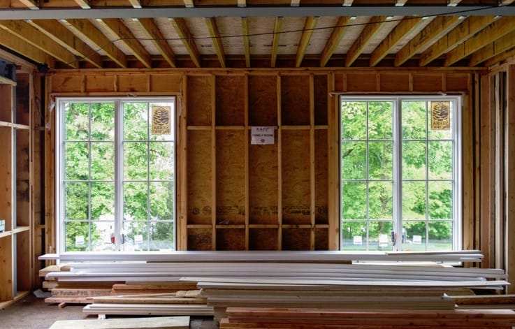 Open family room framing with steel beams and large window openings.