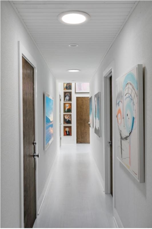 Hallway with bright natural light provided by two sun tunnels on the ceiling. 