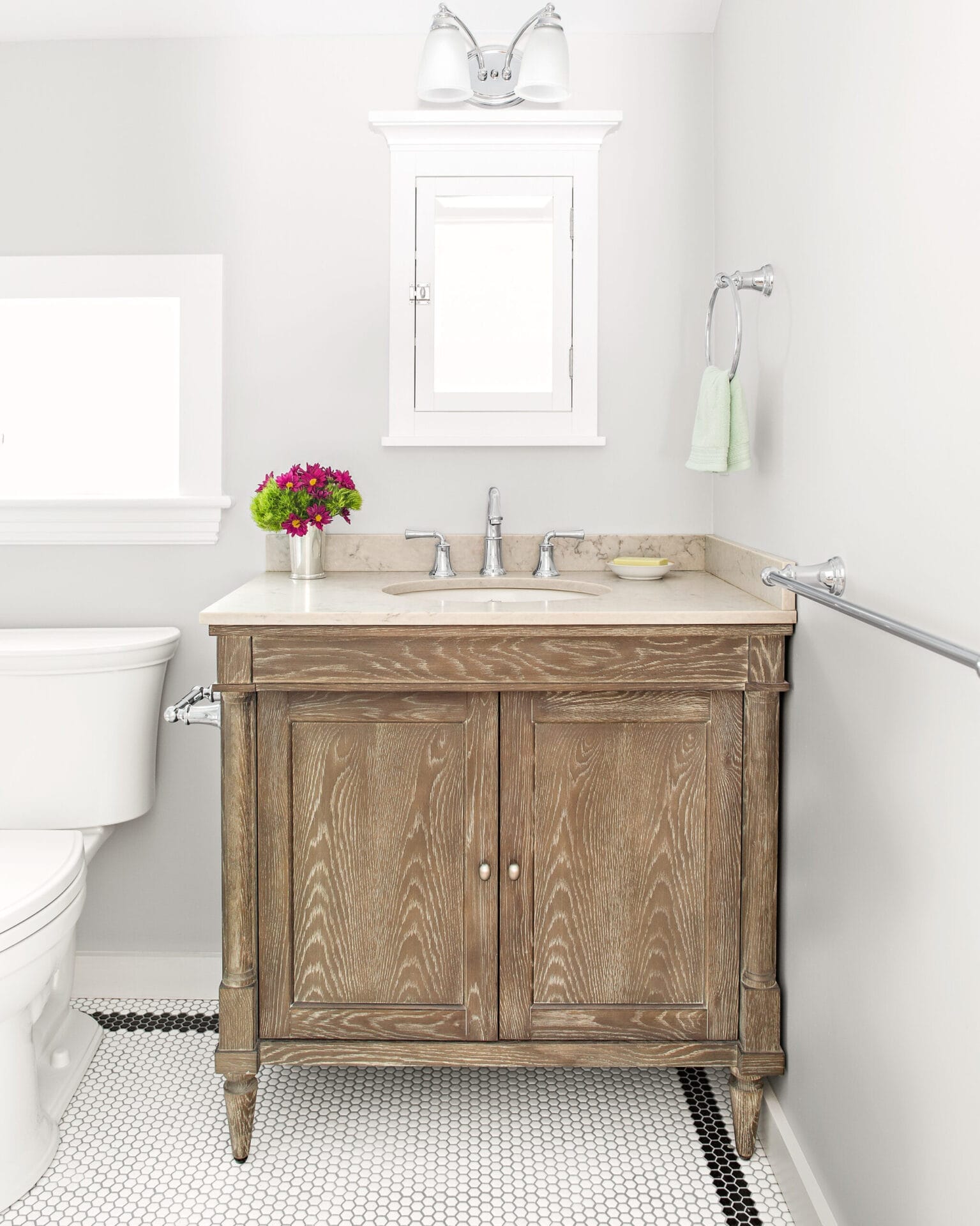 Guest bathroom with pale-gray walls and distressed-wood vanity.