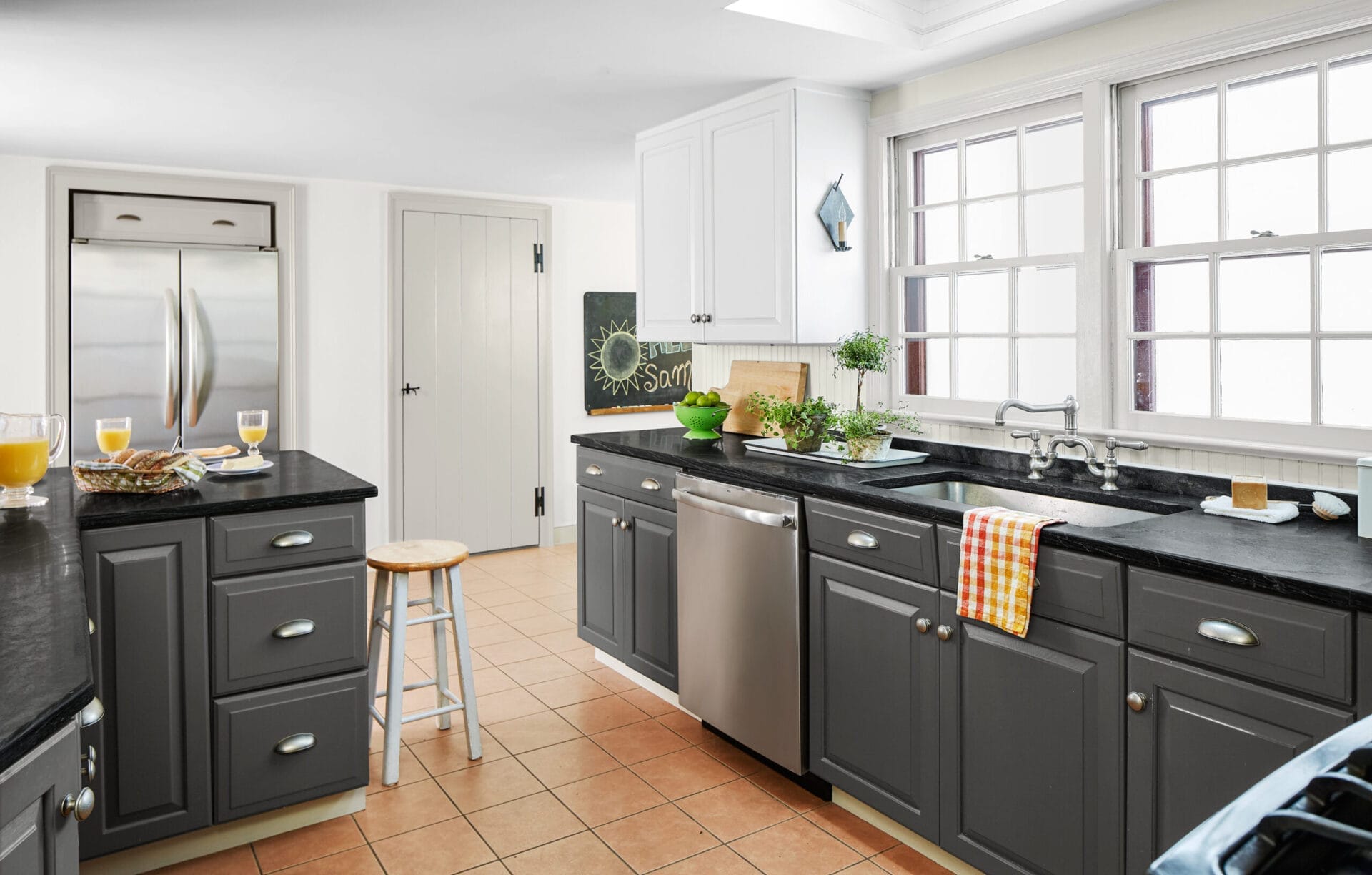 A kitchen with gray base cabinets and open shelving.