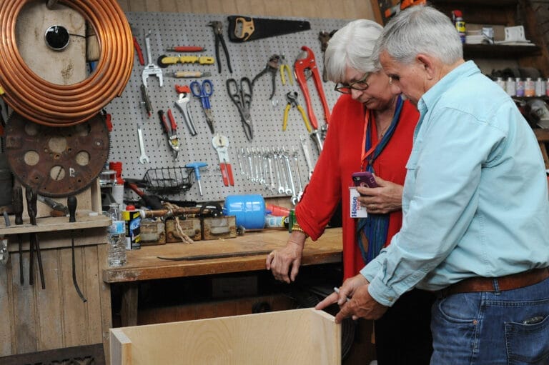 Tommy Award winner Diane Bostow receiving staircase construction advice from Tom Silva using scrap lumber and marker demonstration.