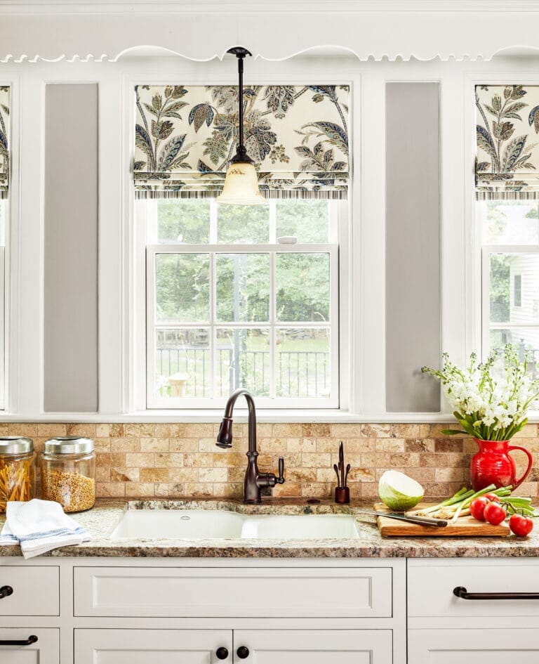 Tumbled travertine backsplash with color variations complementing granite countertop.