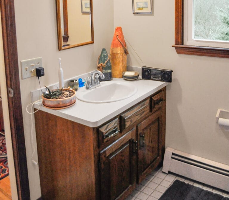 Divided two-part bathroom with single sink in vestibule separated from main area before renovation.