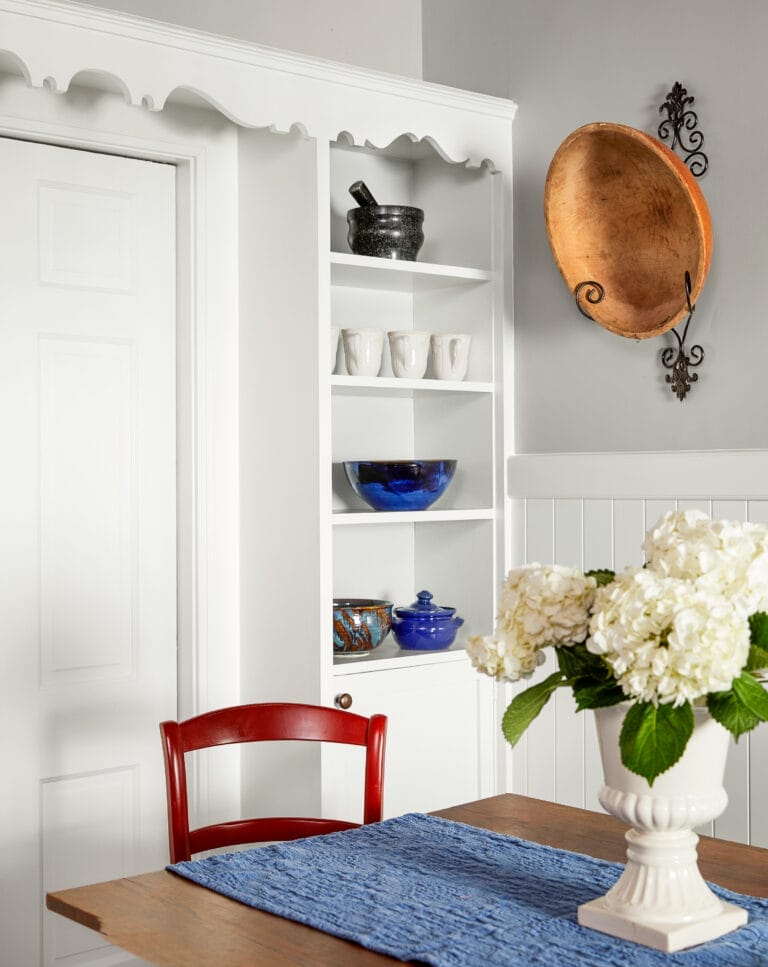 Original built-in cabinet with scalloped trim matching kitchen window valance.