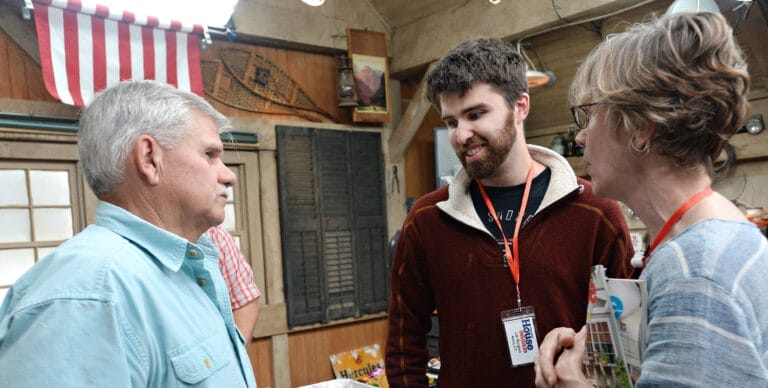 Jon Burgess from Avon, Connecticut, with mother Carla showing Tom Silva antique family masonry books in the workshop.