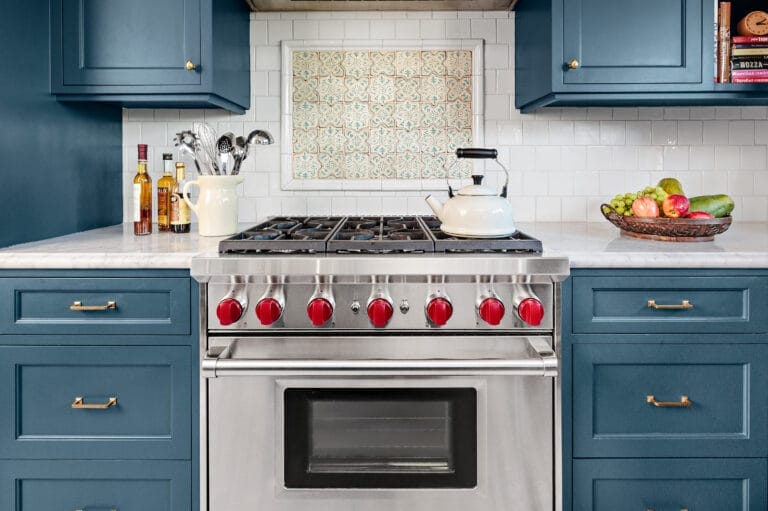 Handmade Moorish tile backsplash inset complementing blue cabinet color.