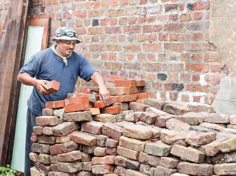 Rigoberto Morales sorting through salvaged bricks.