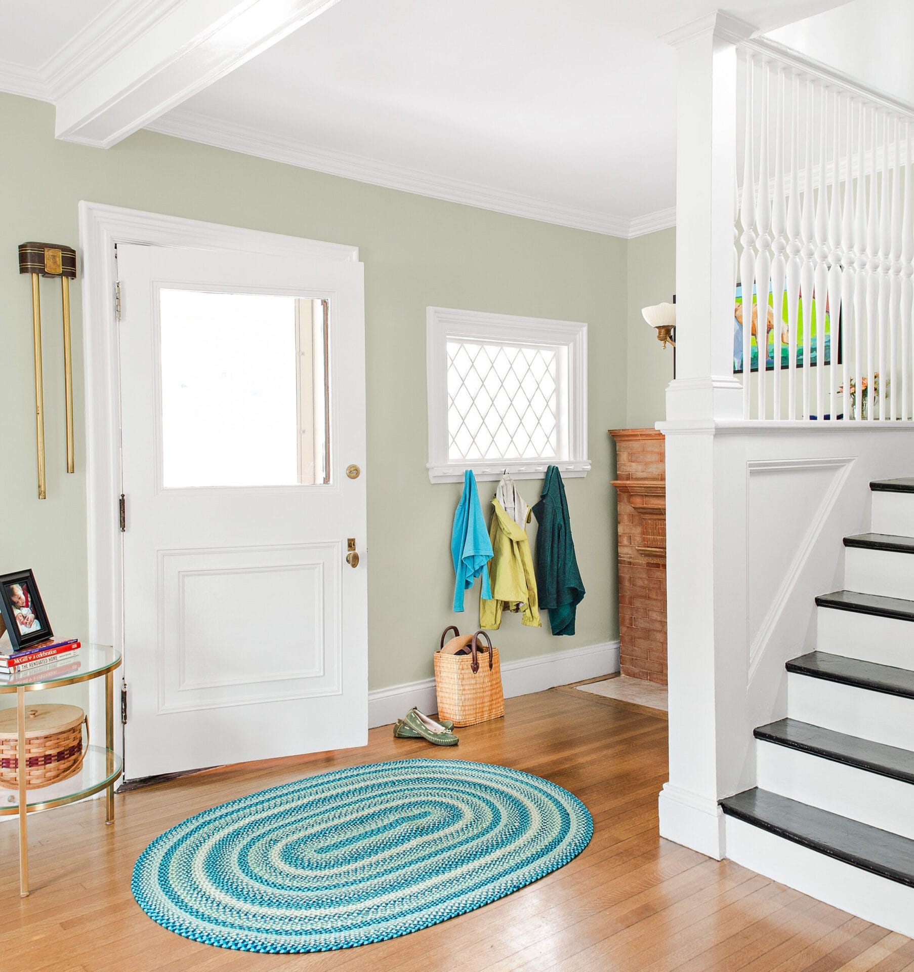 Entry hall with diamond-pane window and Victorian-era staircase balusters.