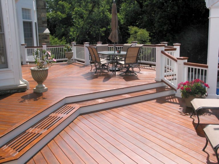 Tropical hardwood deck with two levels and patio furniture.