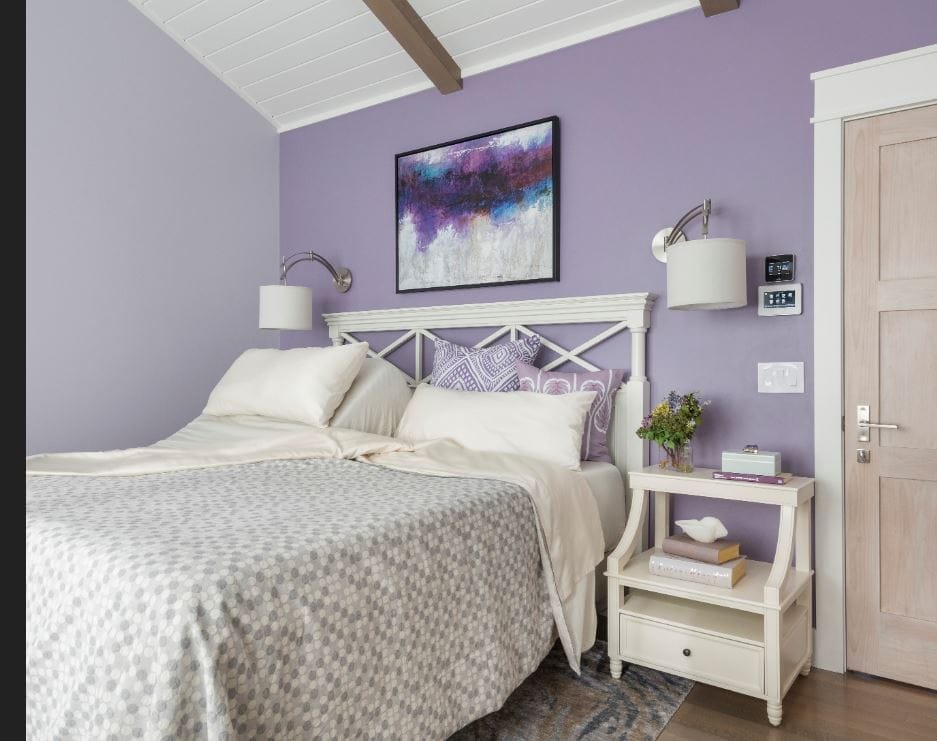 A bedroom with a purple color palette. 