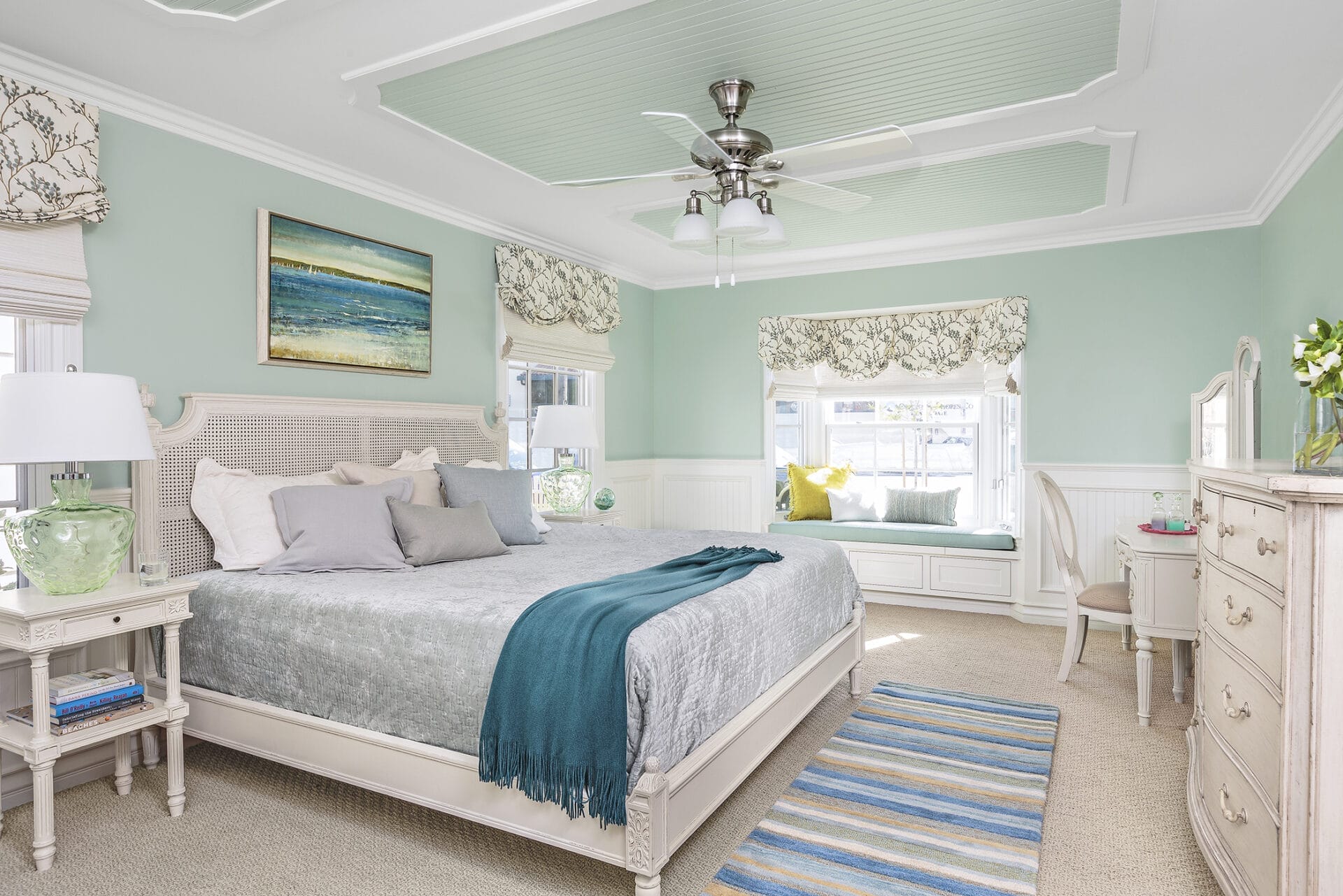 A bedroom with seafoam greed walls and decorations.