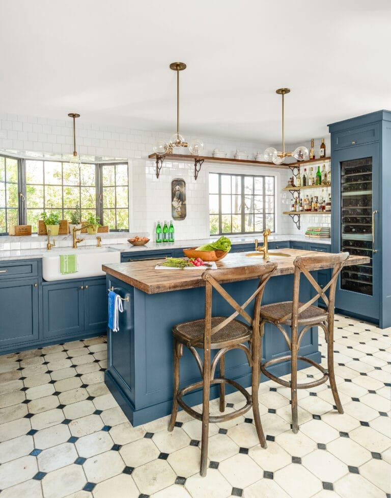 Open kitchen after renovation with multiuse island and blue painted cabinets.
