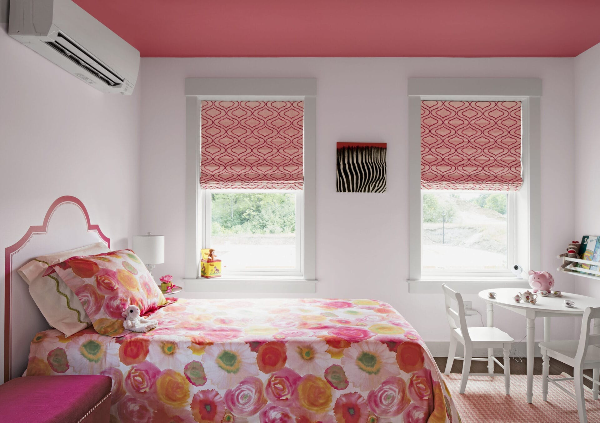 A bed room decorated with bright pinks and reds.