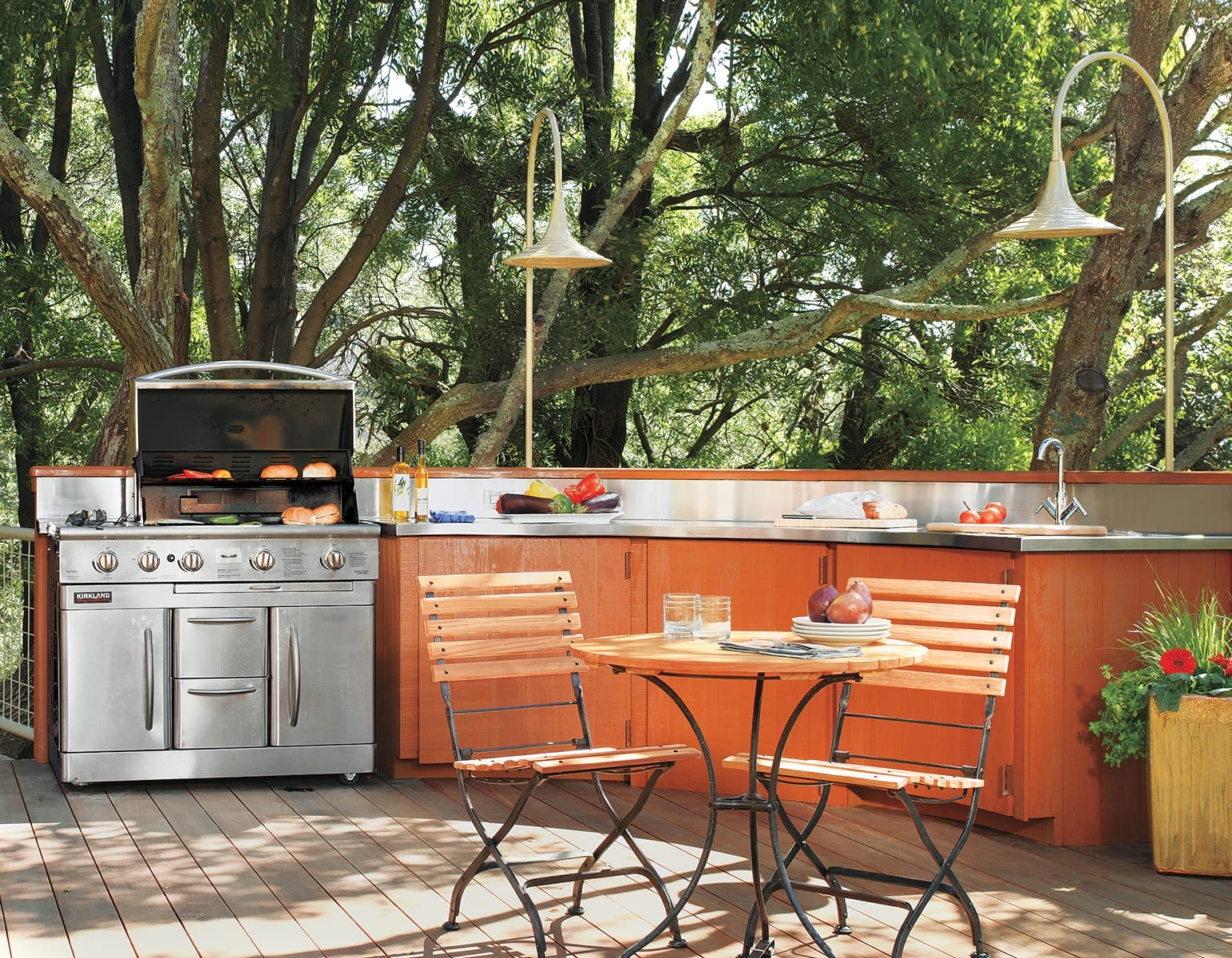 Deck with outdoor kitchen, grill, and chair and table set.