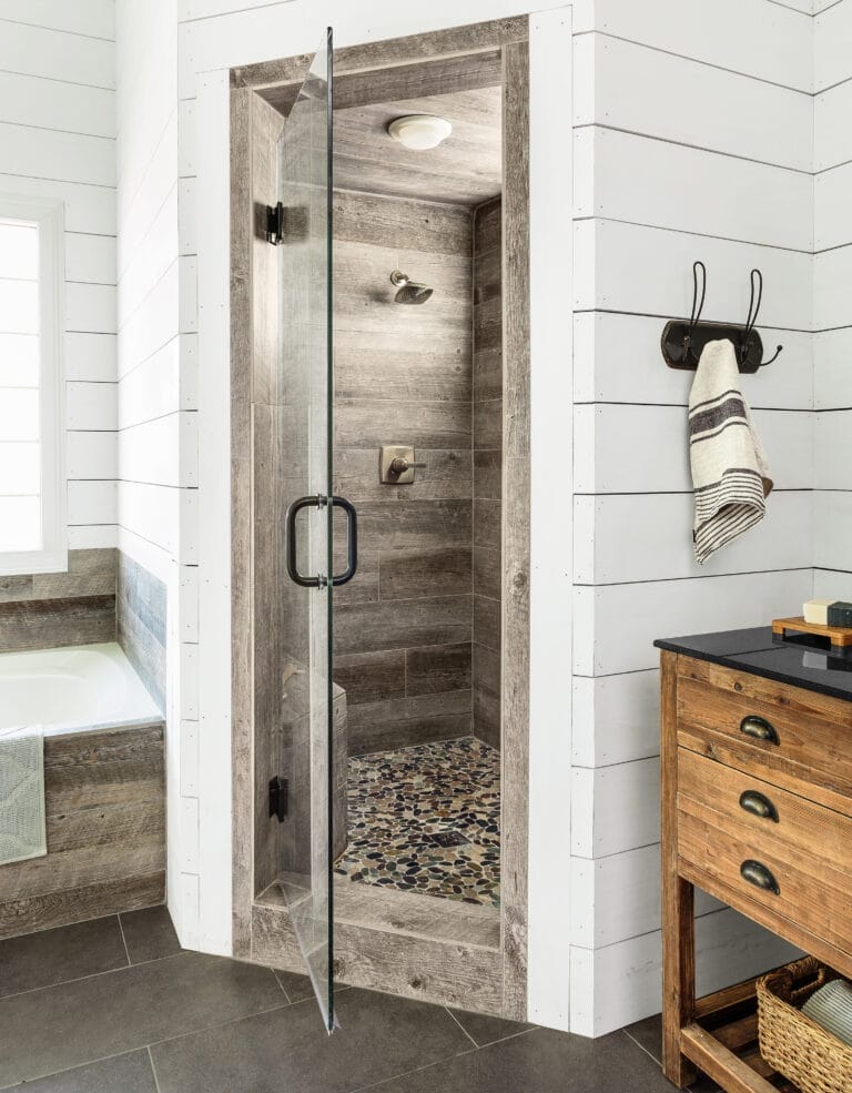 Shower upgrade with porcelain planks laid over old tile and sleek new frameless glass door.