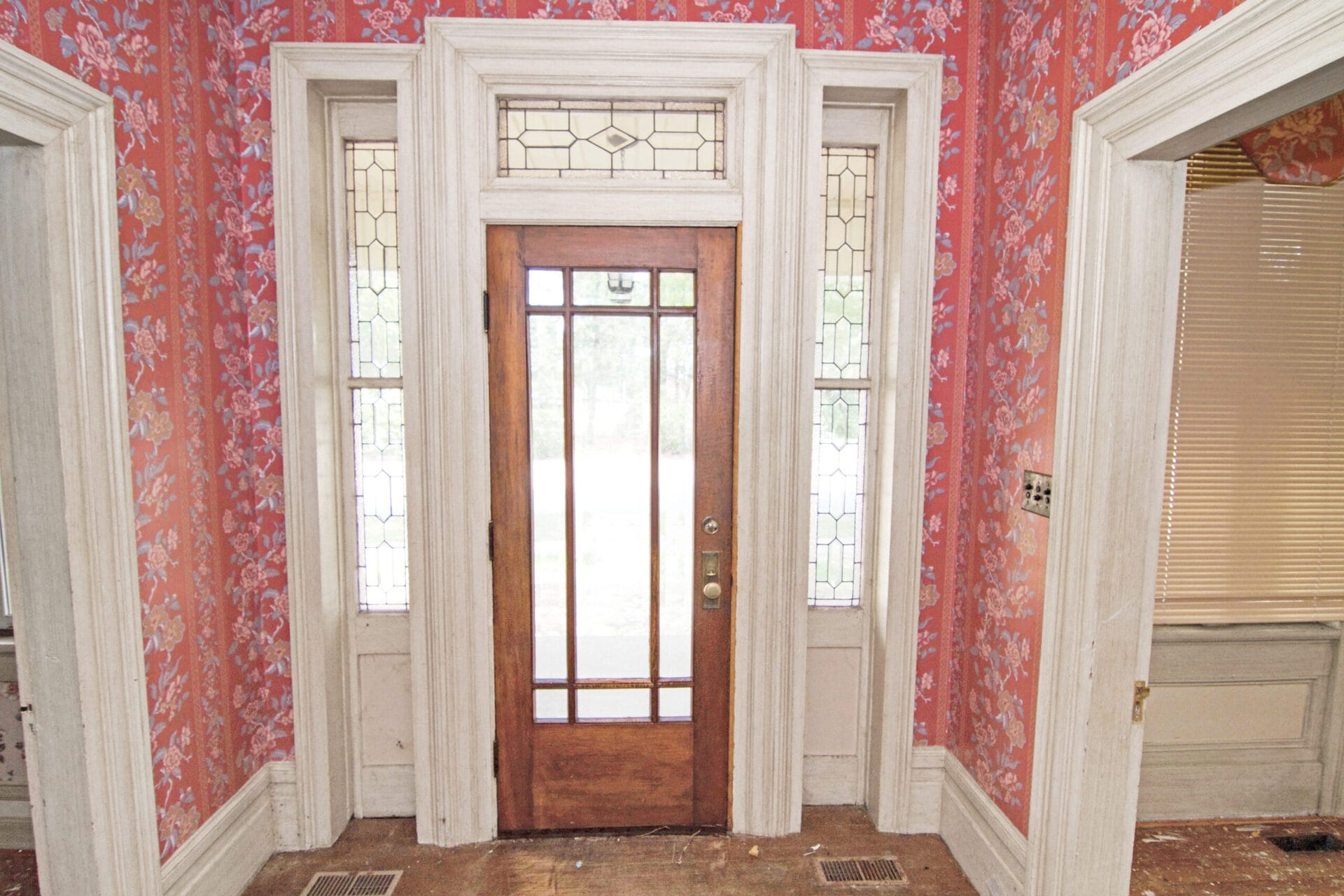 Patterned wallpaper on the walls of the entryway.