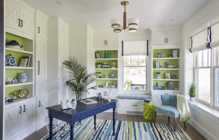 Home office with built-in shelving and bright blue vintage desk.