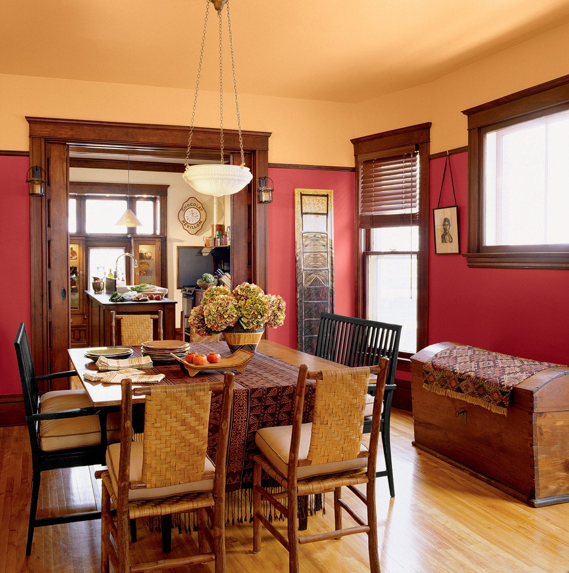 Craftsman dining room with warm scarlet walls complementing orange-toned wood details.