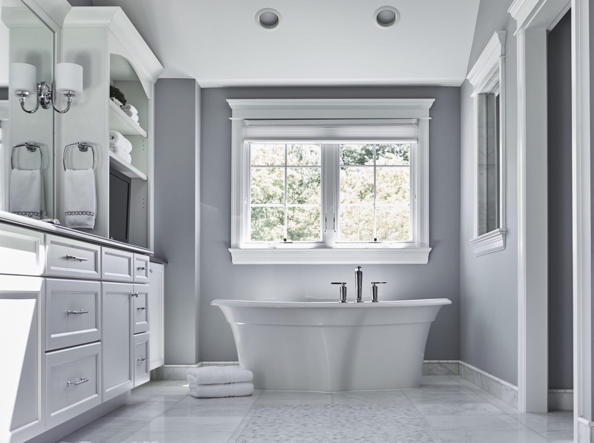 A pair of windows over a bathrub.