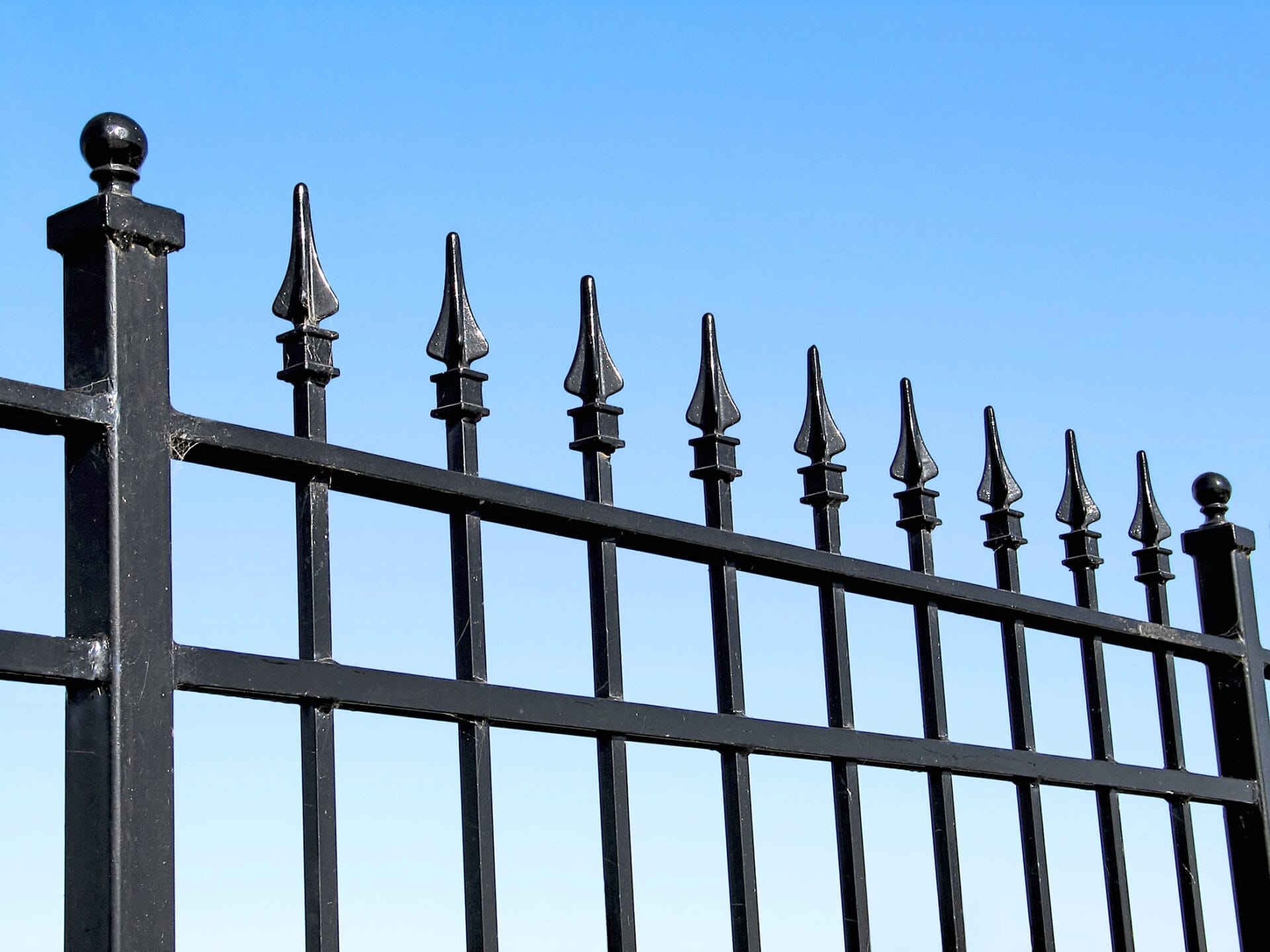 A metal fence in need of some cleaning and maintenance.