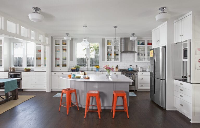 A wide view of the kitchen with bright island stools.