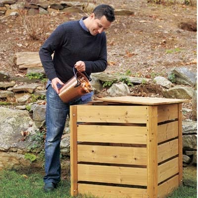Aman pouring scraps into a compost bin