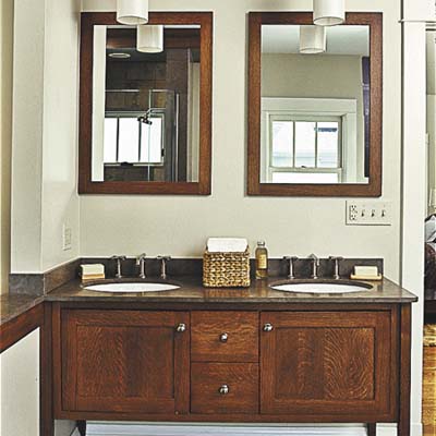 Wooden vanity beneath two matching mirrors.