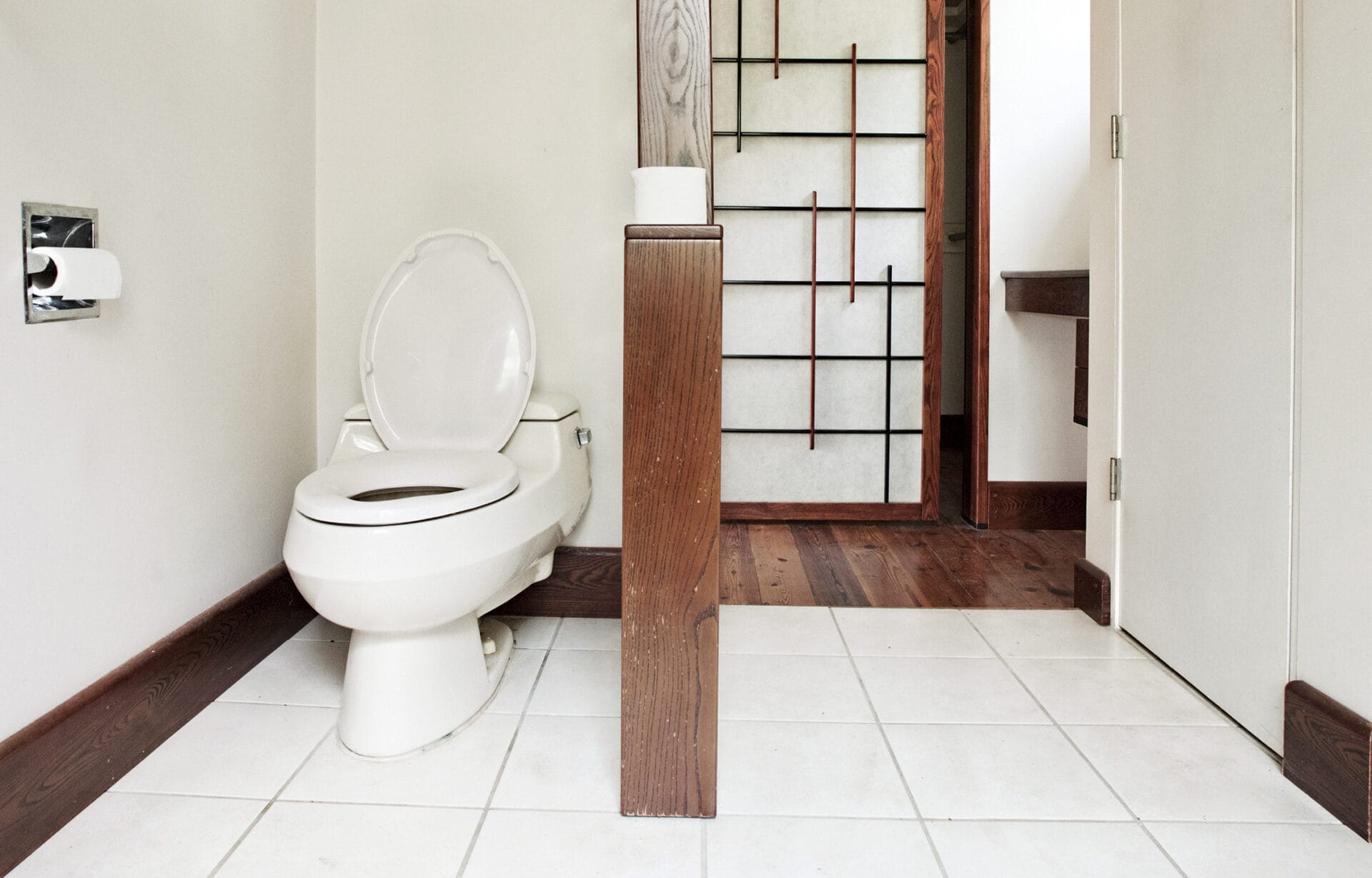 Awkward bathroom layout with dated finishes and no tub before master suite renovation.