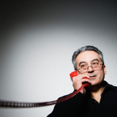 A man talking on a corded phone