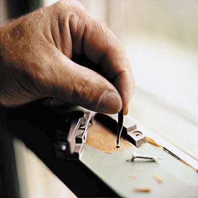 using small tools to tighten a drafty window