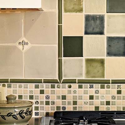 Coordinated tile backsplash with dragonfly inset and mixed patterns.