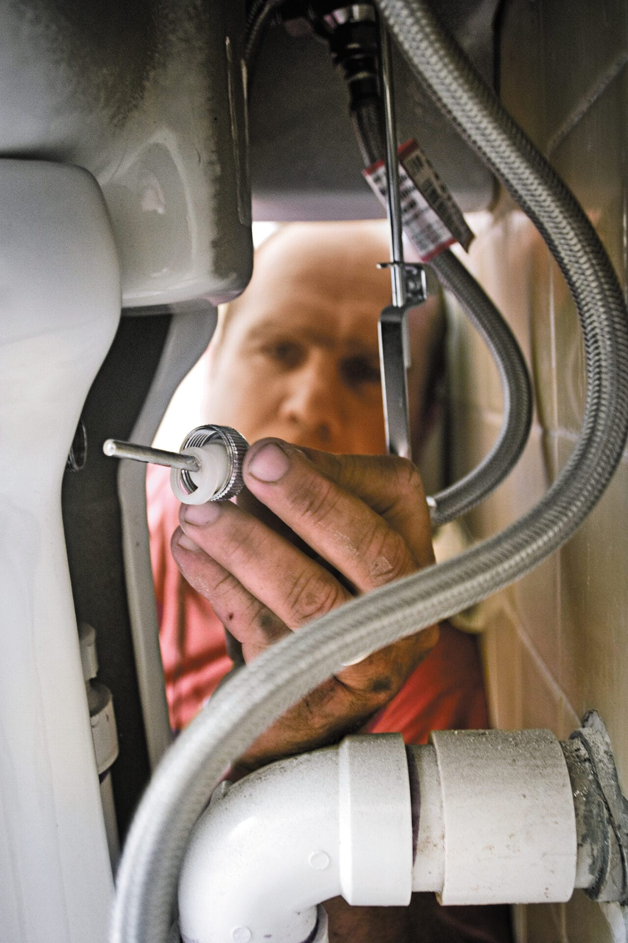 removing a hose from a sink to unclog it