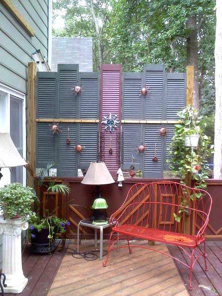 A deck with a salvaged shutter wall.
