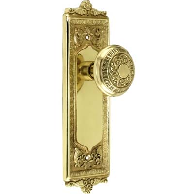 Brass door handle and plate with egg-and-dart styling and decorative knobs.
