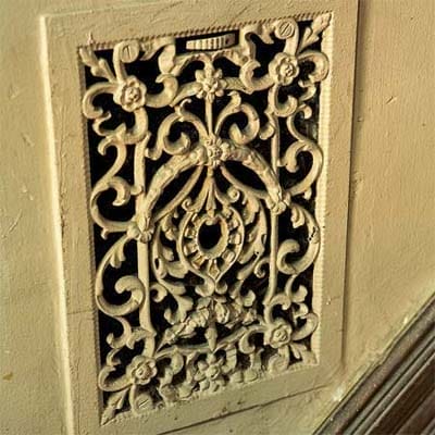 Intricate cast metal vent cover from original coal furnace heating system.