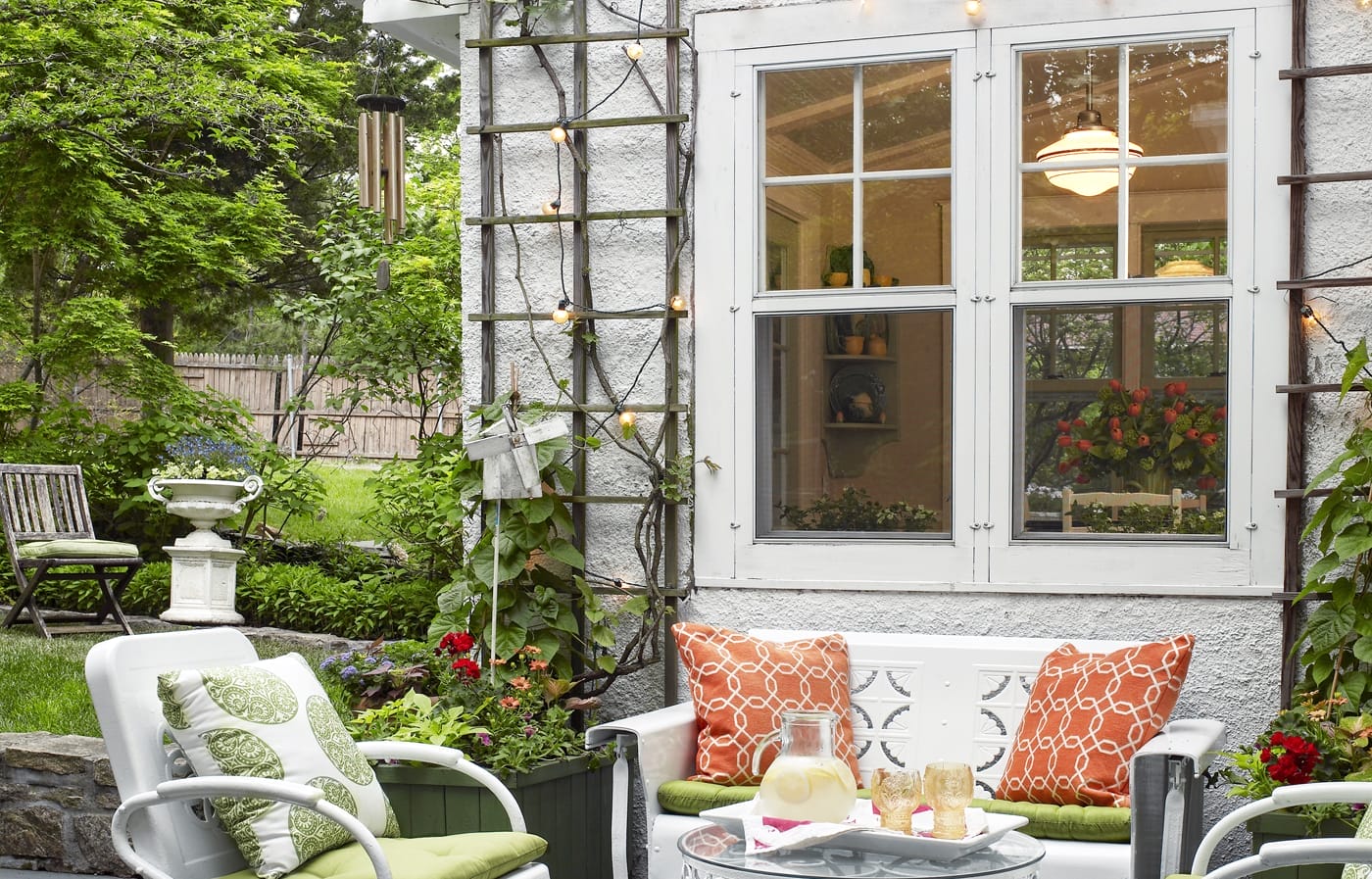 Colorful outdoor patio with double hung windows, string lights, and patio furniture. 